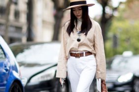 A showgoer at Paris Fashion Week wears a straw boater hat